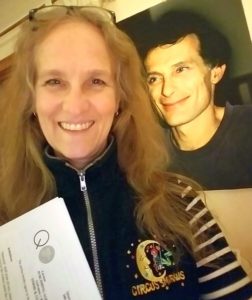 Jackie Davis with her book contract and a photo of her late husband Rick Davis
